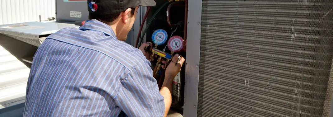 HVAC technician servicing a condenser unit in Tonganoxie