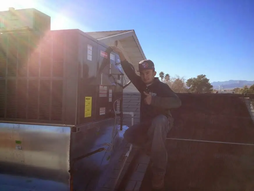 HVAC technician performing AC Tune-Up on a rooftop unit in Tonganoxie